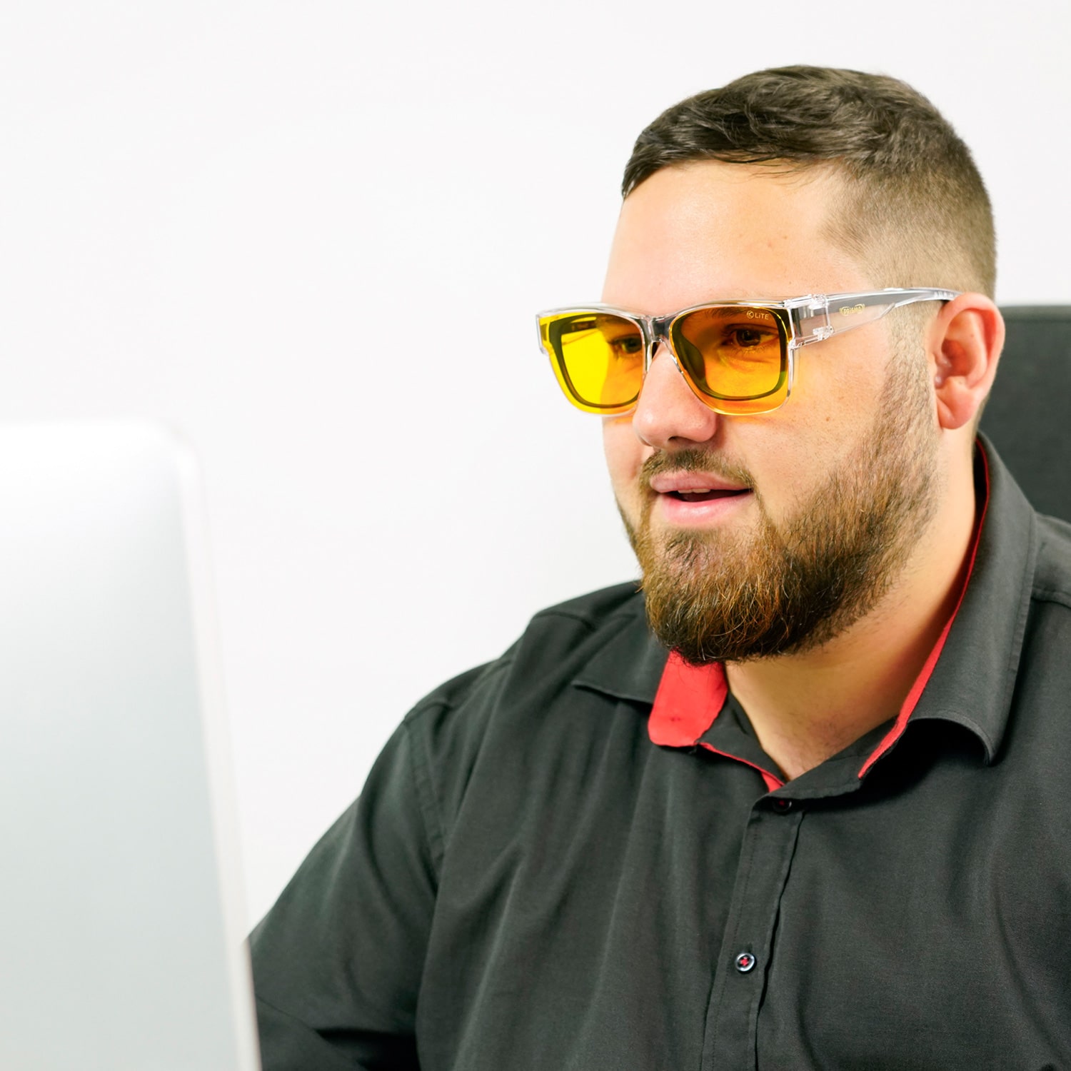 Männliches Model mit LITE95 OVER1-Überziehbrille beim Arbeiten vorm PC